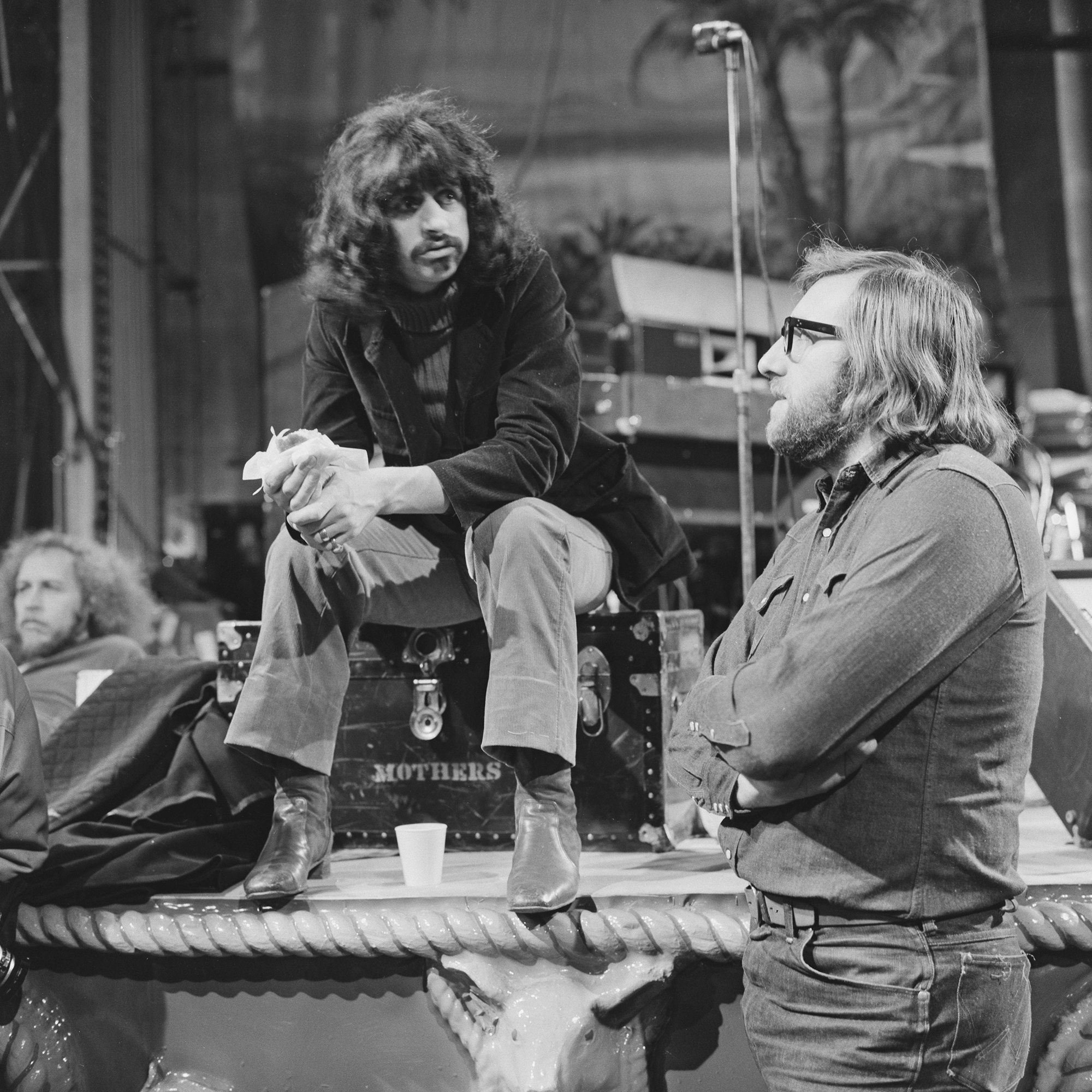 Ringo Starr, in costume, talks with Beatles assistant and roadie Mal Evans during a rehearsal break at the Royal Albert Hall in London in February 1971. Photo via Evening Standard/Hulton Archive/Getty Images.